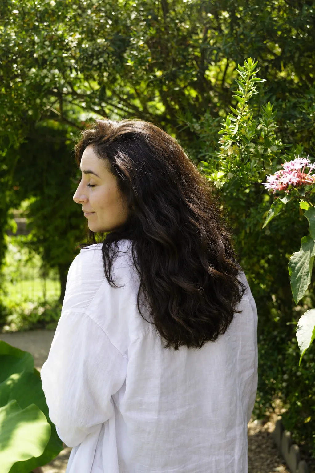 Lisa Giussani de profil dans un jardin fleuri